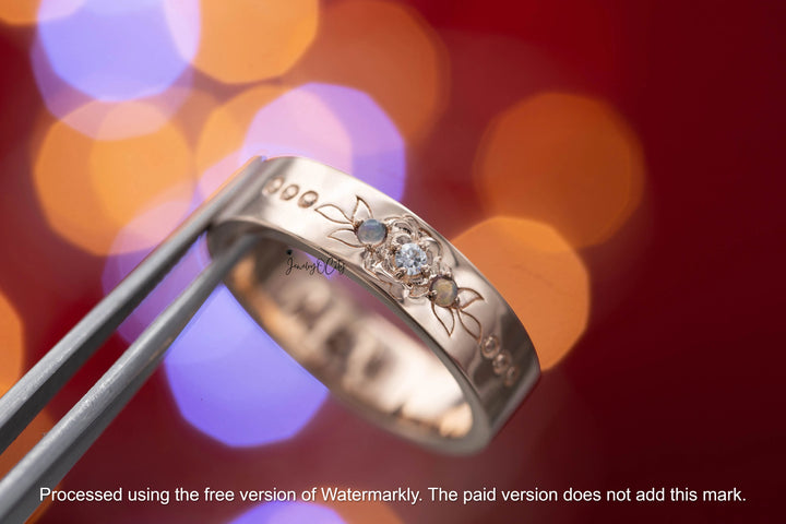 Silver ring with engraved design against a blurred colorful background