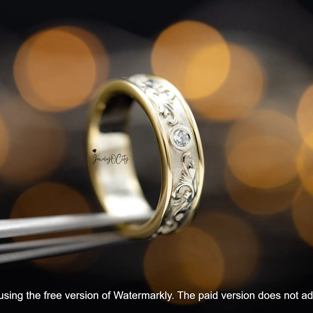Gold ring with intricate design held by tweezers against a blurred bokeh background
