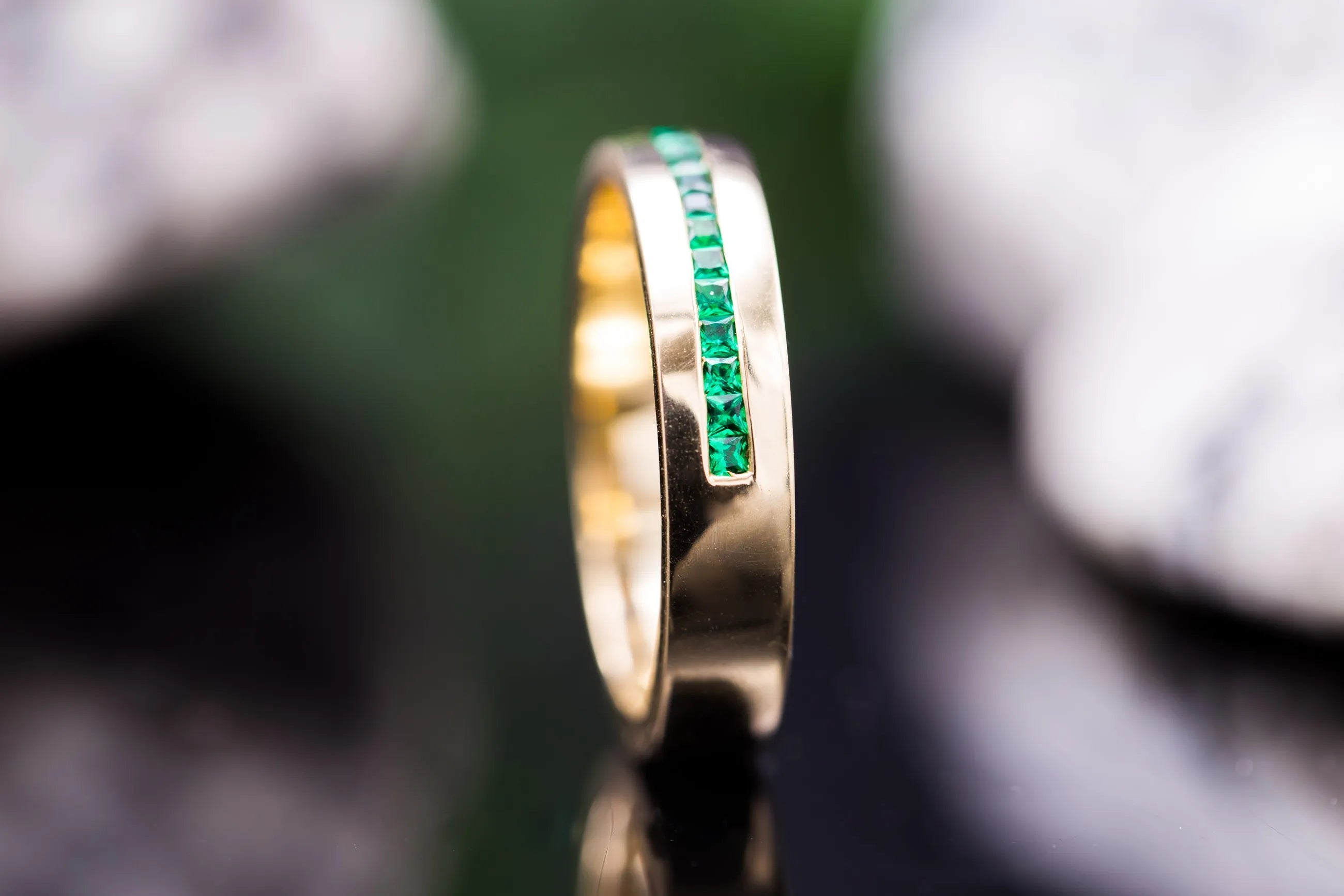 half eternity emerald gemstone band side view